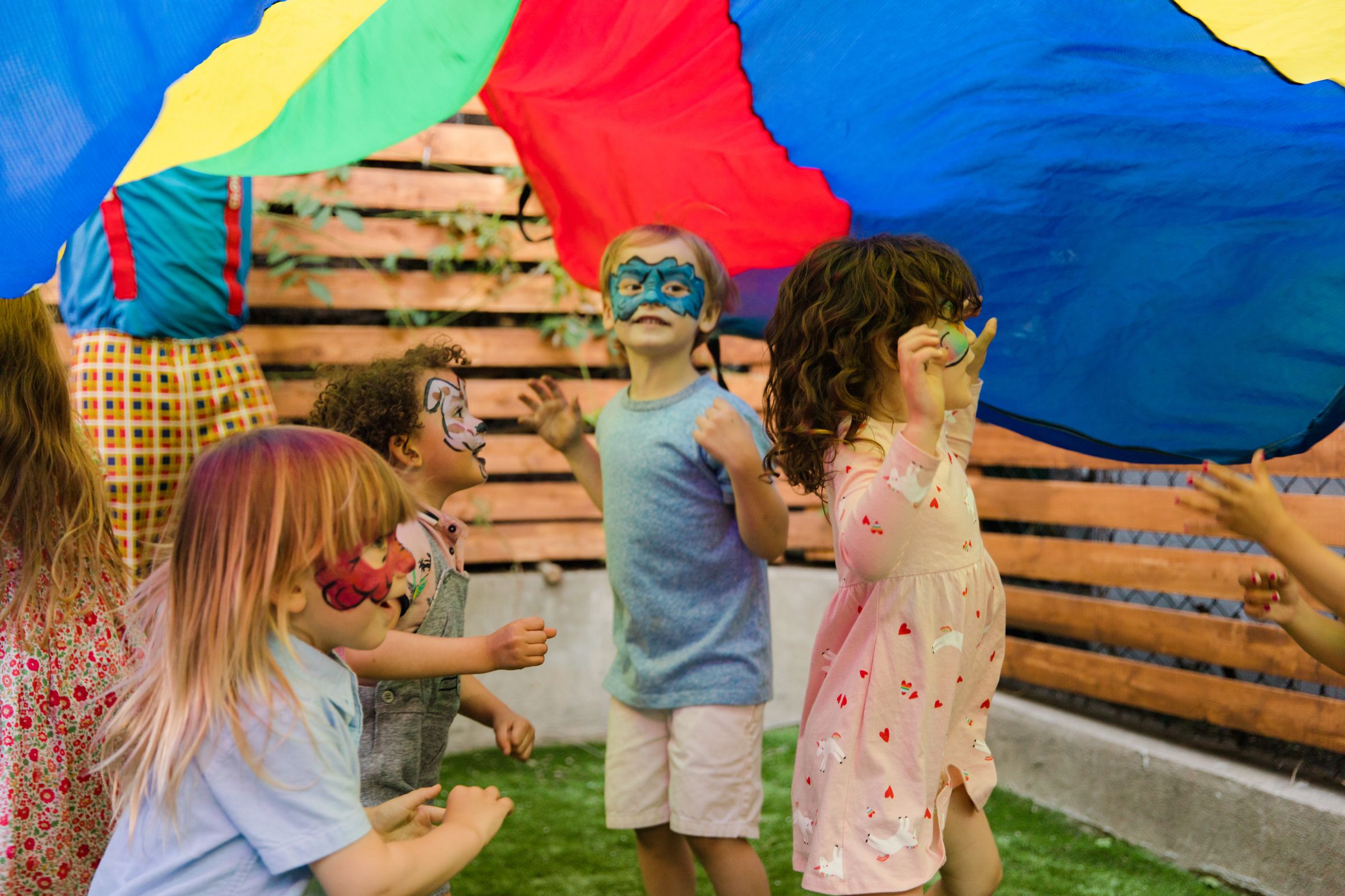 Face-painted kids playing together at an outdoor party